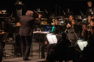 Conducting a live symphony orchestra in sync with the movie playing on the big screen